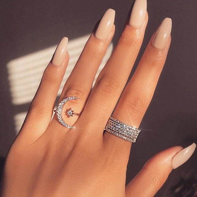 Silver-tone crescent moon crystal ring with star detail, plus matching band ring