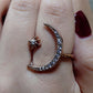 Silver-tone crescent moon crystal ring with star detail, close-up on finger