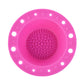 Hot pink silicone makeup brush cleaning bowl with central textured scrubbing pad and rim holes.