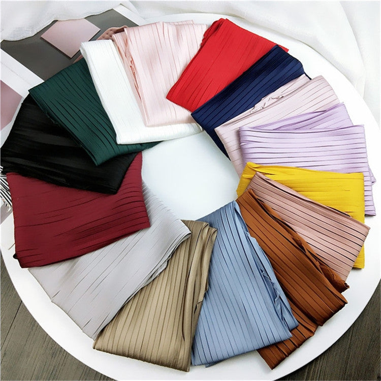 Color assortment of pleated silk square scarves in red, navy, green, cream, and tan