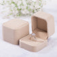 Beige velvet ring jewelry box set, one closed and one open with ring