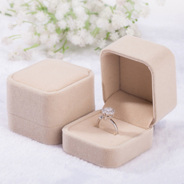 Beige velvet ring jewelry box set, one closed and one open with ring