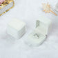 White velvet ring jewelry box set, one closed and one open with silver-toned ring