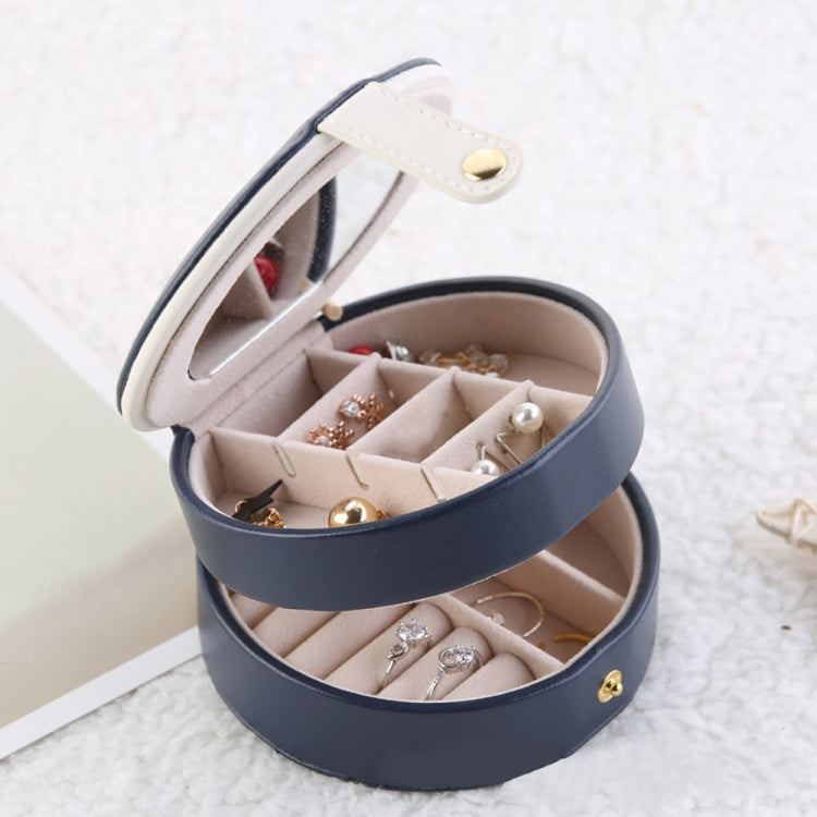 Two-tier jewelry organizer with lid open, holding assorted earrings in divided sections.