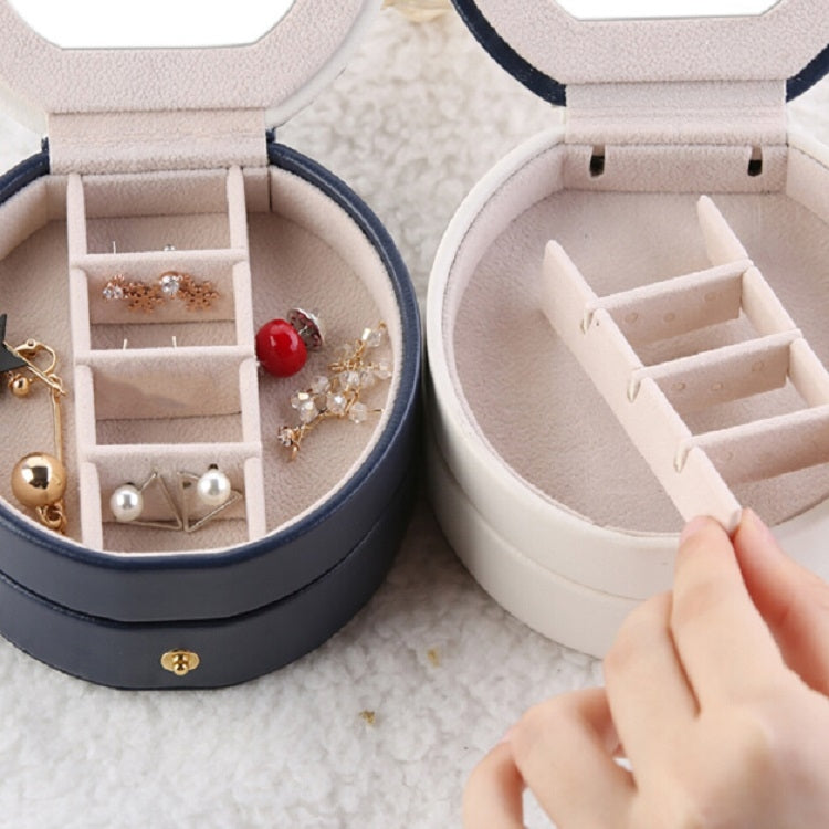 Open two-tier jewelry box with divided inserts for rings and earrings; hand lifts insert.