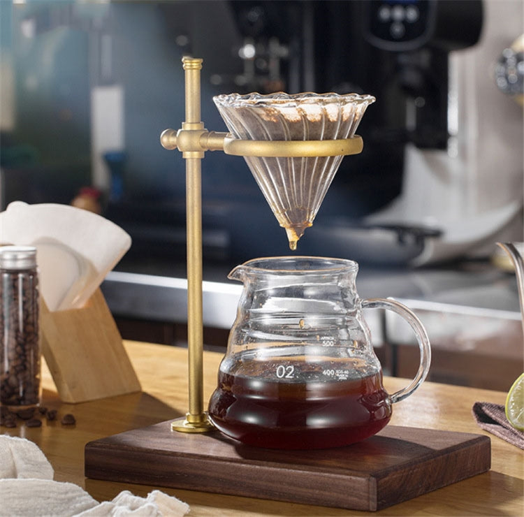 Brass hand coffee filter holder with glass carafe, filter draining into carafe