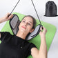 Neck stretcher hammock and eye mask resting on a green mat, person lying back