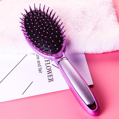 Purple oval hair brush with black bristles and silver grip, air-cushion style.