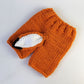 Orange knit pants and fox-ear beanie set with white patch and black outline