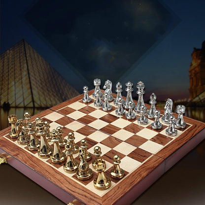 Wooden chess board with light and dark squares and silver and gold metal chess pieces