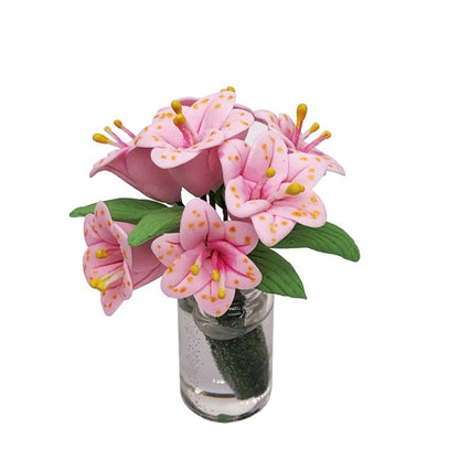 Mini dollhouse lily bouquet in clear glass vase with green leaves and pink flowers