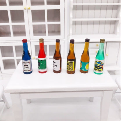 Mini wine drink bottle ornaments set on a dollhouse shelf, assorted blue, red, amber, green.