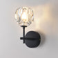 Black crystal wall sconce with faceted glass globe shade and round backplate