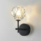 Black crystal wall sconce with round wall plate and faceted crystal globe shade