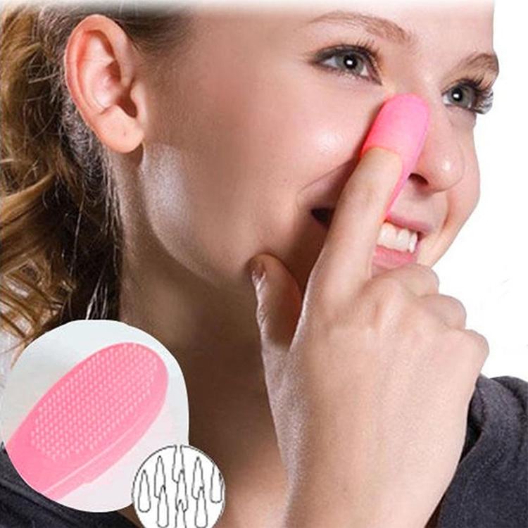 Pink silicone nose cleansing brush with textured tip held against a woman’s nose