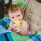 Yellow star-shaped spiky rubber bath ball held by a baby