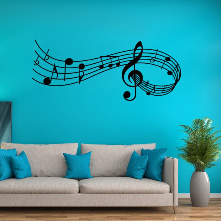 Black music note wall decal with treble clef and curved staff lines on a blue wall