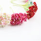 Pink and red flocked plum blossom mini flower stems on green branches