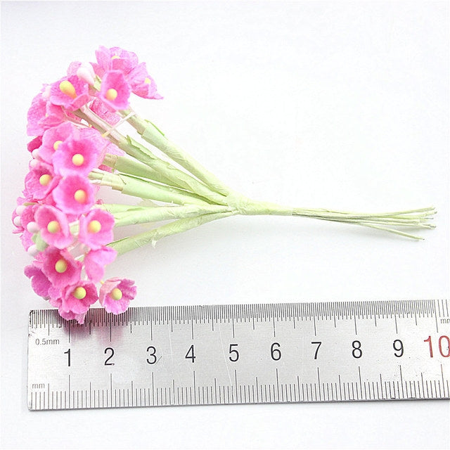 Pink flocked plum blossom mini flower cluster with green stem and ruler