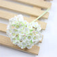 White mini faux flocked plum blossom flower on a decorative branch stem