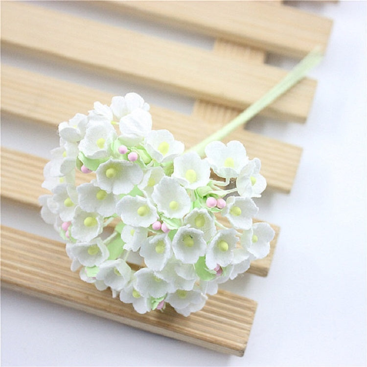 White mini faux flocked plum blossom flower on a decorative branch stem