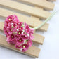 Pink mini faux flocked plum blossom flower on a decorative branch stem