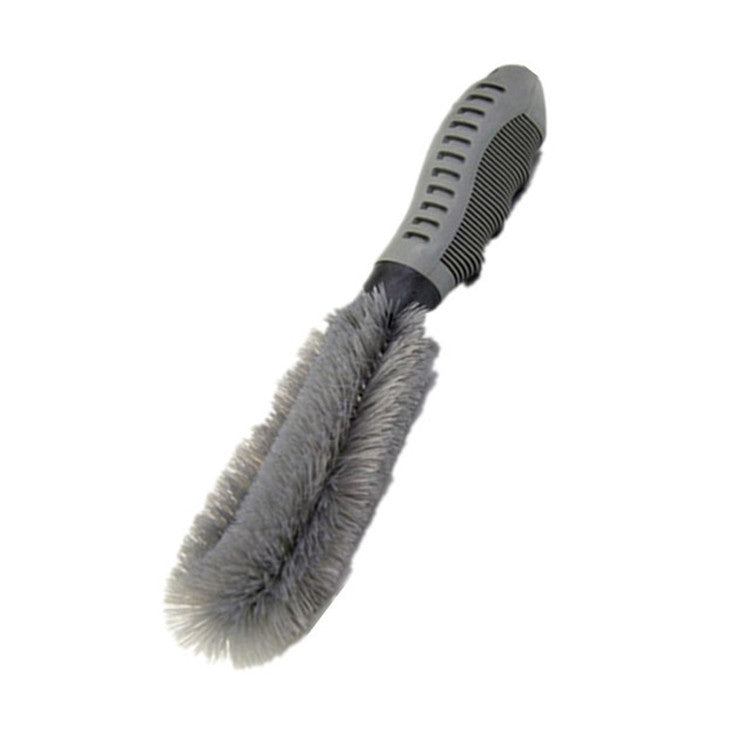Car wheel cleaning brush with gray bristle head and ribbed black handle, angled view