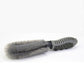Car wheel cleaning brush lying flat, gray bristles on black ribbed handle