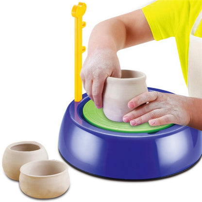 Blue mini pottery wheel with green spinning pad, clay cup shaped by hands