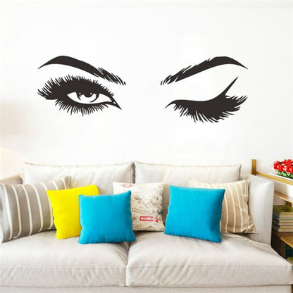 Black eye and eyebrow wall sticker set with two stylized eye decals above a sofa.