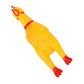 Yellow rubber chicken squeaky pet toy with red beak and feet, lying down.