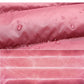 Pink water-resistant puffer fabric with droplets and stitched seam detail