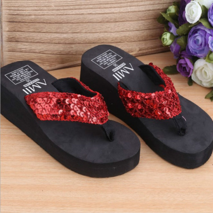 Pair of red sequin thong wedge flip-flops on black platform soles
