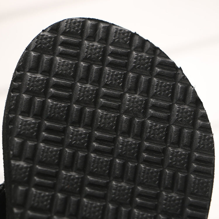 Textured tread pattern on the bottom of a black wedge flip-flop sole