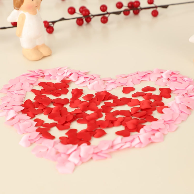Heart-shaped faux petals in pink, red, and white on a surface for decoration