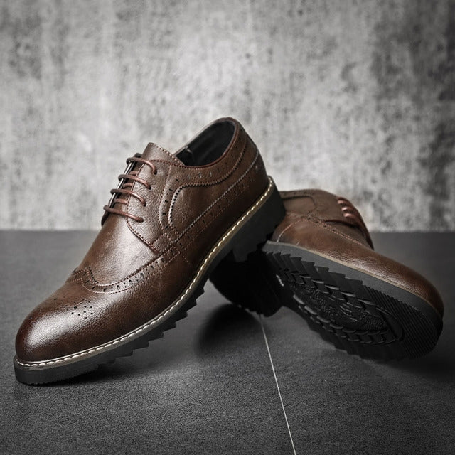 Brown lace-up brogue oxford shoes with wingtip perforations and textured tread sole