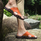 Men's orange slide sandals with open toe, stud accents, and red-trimmed sole