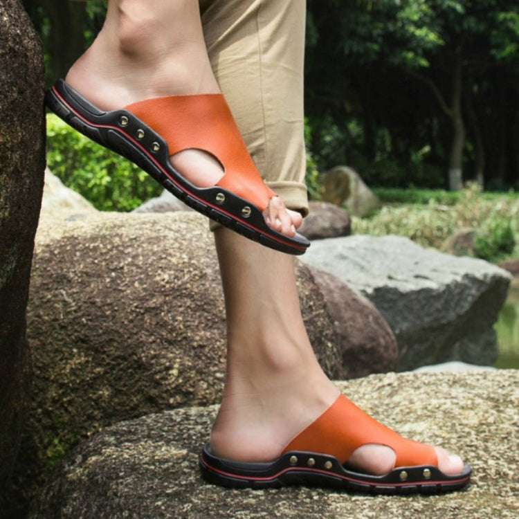 Men's orange slide sandals with open toe, stud accents, and red-trimmed sole