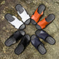 Assorted men's slide sandals in white, black, navy, and orange colors