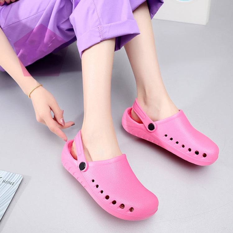 Pink slip-on medical clogs on feet with perforated upper and heel strap