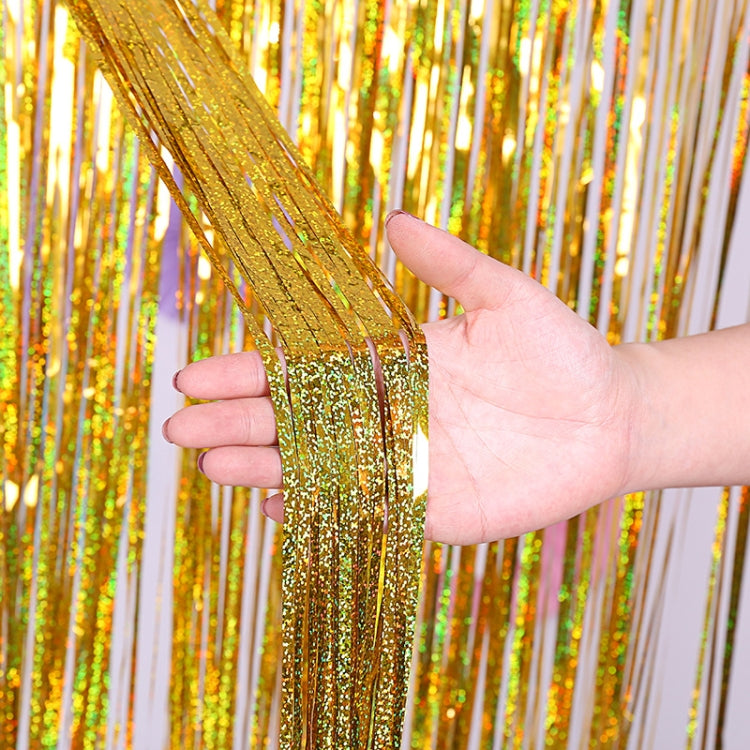 Gold holographic foil tinsel curtain with glitter strands, held in a hand.