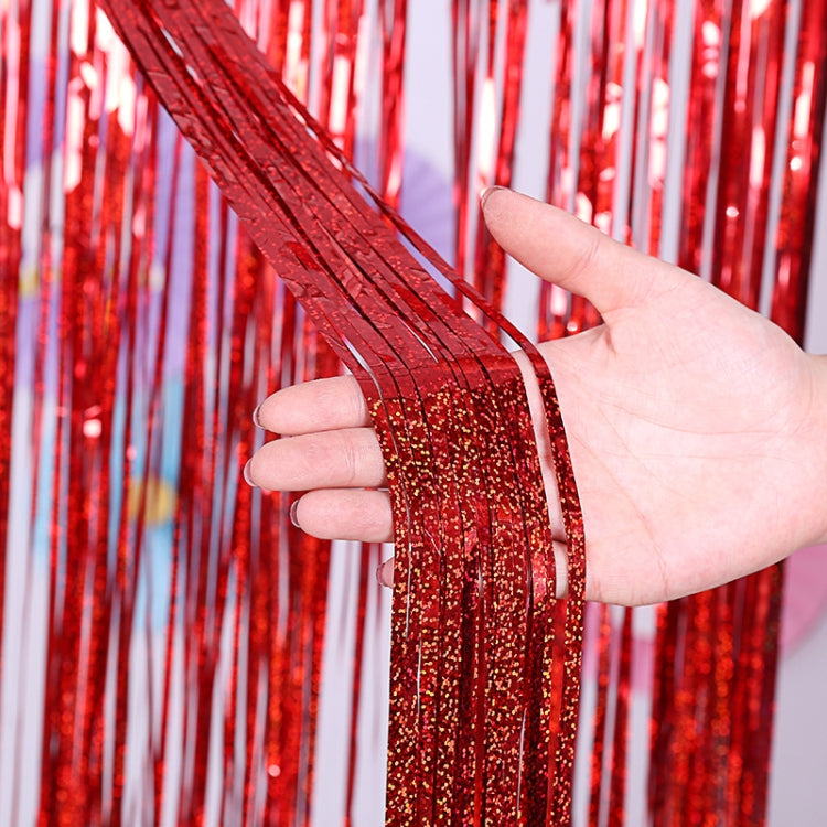 Red metallic foil tinsel curtain with glitter strands, held up in hand.