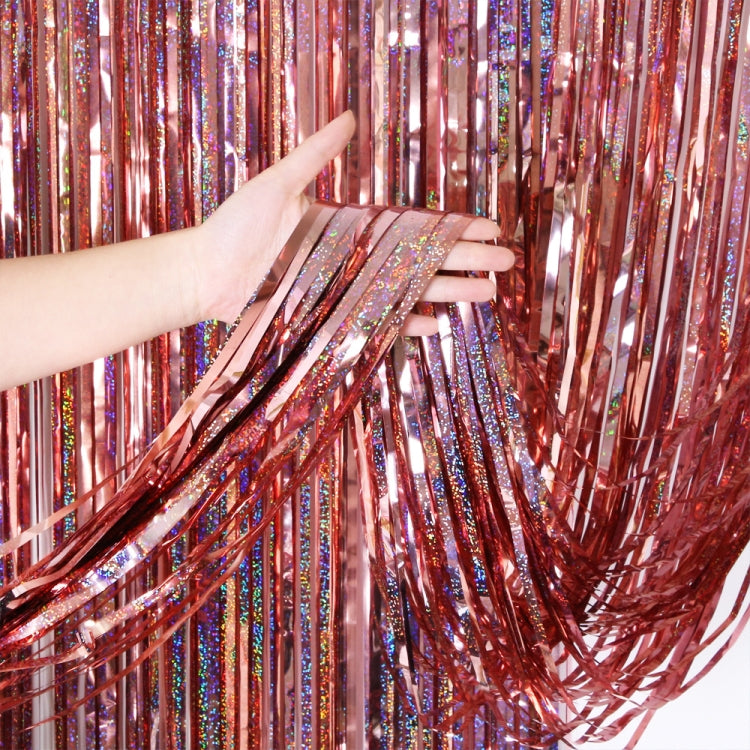 Laser rain tinsel foil curtain, red metallic glitter strands tied at top, hand holding