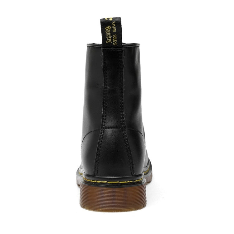 Black ankle boots with lace-up opening and brown tread sole, back view