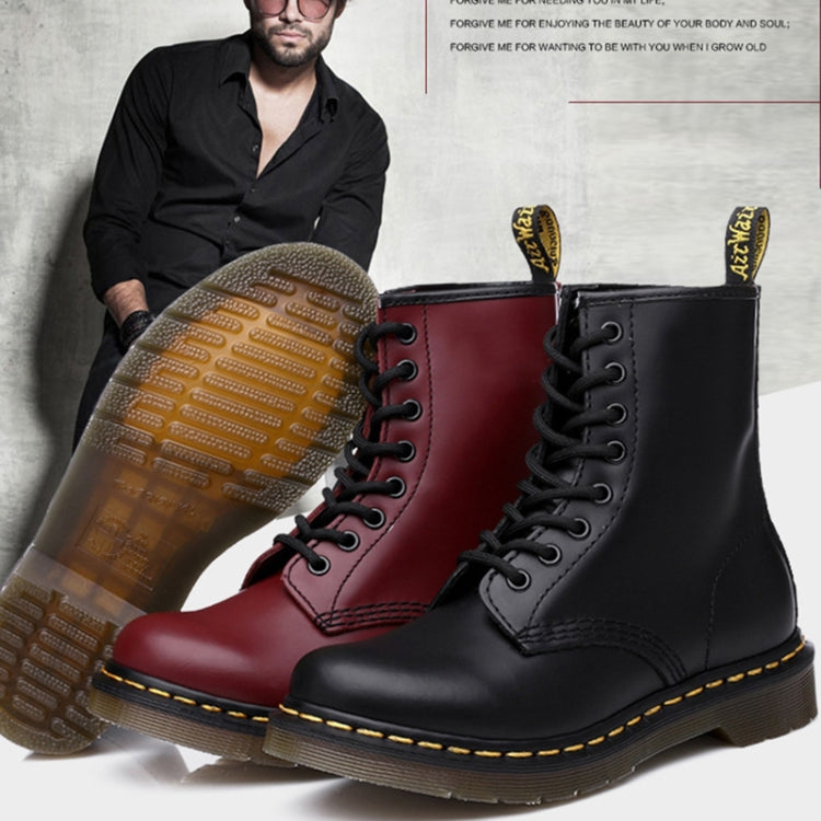 Pair of boots in red and black with yellow welt stitching and treaded soles