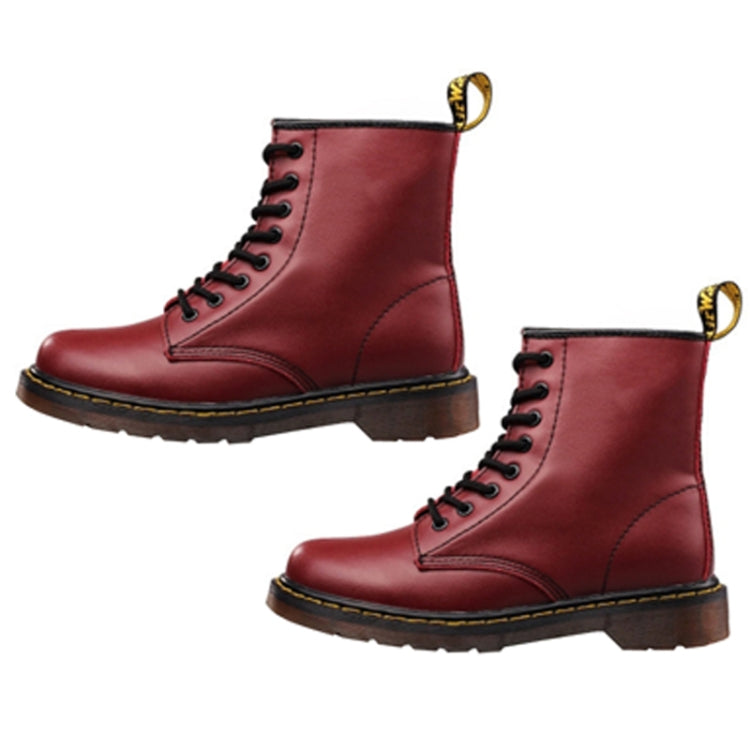 Pair of red lace-up Martin ankle boots with yellow eyelets and stitched panels