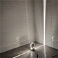 LED wall spotlight with semicircle head glowing white light in corner