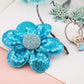 Blue sequin flower hair accessory with gray center on headband