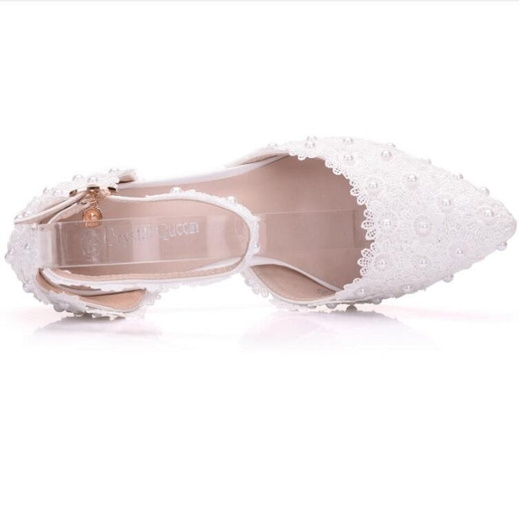 White lace pointed-toe shoe showing open insole and ankle strap with silver buckle
