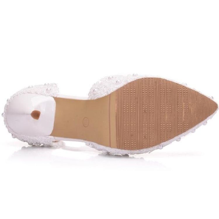 White lace pointed-toe high-heel with textured sole and small charm on the strap